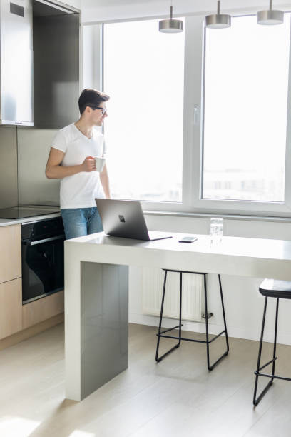 istock Young handsome man drinking morning coffee in his kitchen 1225046572