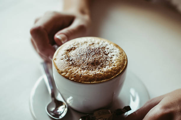istock Coffee cappuccino with foam. Women's hands with cap 1225050048