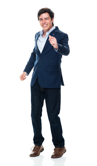 Front view of aged 20-29 years old with short hair caucasian young male business person dancing in front of white background wearing jacket who is feeling joy