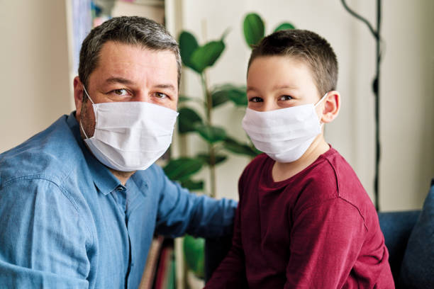 istock Father and son wearing surgical protective mask together. 1225055261