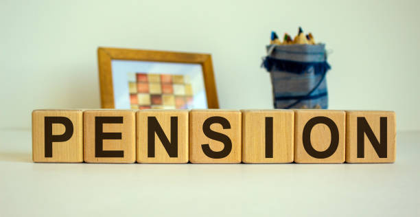 wooden cubes with the inscription 'pension'. frame with a picture and a bag with pencils in the background. beautiful white background, copy space. - single word love wood typescript imagens e fotografias de stock