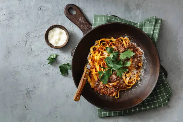 Classic Tagliatelle with Sauce Bolognese. Flat lay top-down composition on concrete background