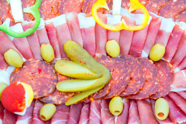Traditional Appetizer Savory Dish Meze for wedding celebration, Croatia from  prosciutto, cheese, sausages, olives, green peppers and sour cucumber.