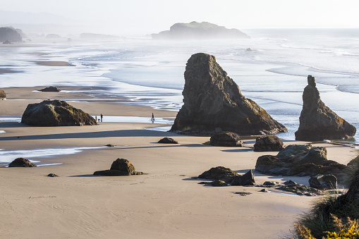 Tranquil afternoon in Bandon Oregon with low tides revealing a sandy beach with large rocks adding drama to the landscape in the southern Oregon Coast
