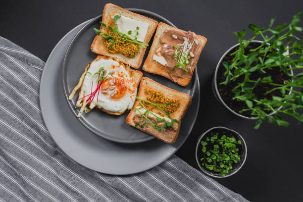 istock Variety of sandwiches for breakfast, snack, appetizers with fried egg, peanut paste, pea microgreen. Flat lay, top view 1225062103