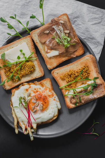 istock Variety of sandwiches for breakfast, snack, appetizers with fried egg, peanut paste, pea microgreen. Flat lay, top view 1225062105