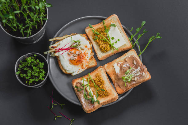 istock Variety of sandwiches for breakfast, snack, appetizers with fried egg, peanut paste, pea microgreen. Flat lay, top view 1225062120