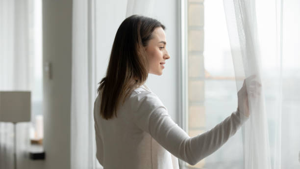 istock Young woman look in window dreaming or pondering 1225064103