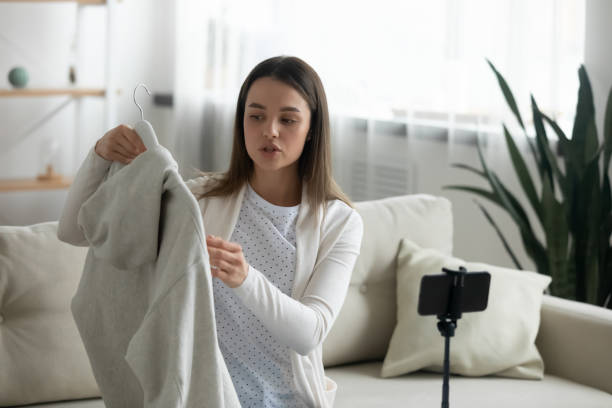 młoda kobieta strzelać rozpakowywanie odzież wideo zakupy online - presenter young adult women marketing zdjęcia i obrazy z banku zdjęć