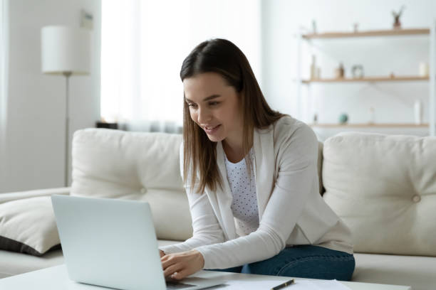 istock Happy young woman browsing internet on laptop at home 1225064251