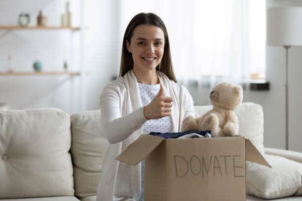 istock Smiling young woman stack clothes in box recommend donating 1225064288