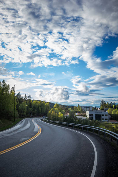 istock Road down the hill in norway with forest and town 1225065746