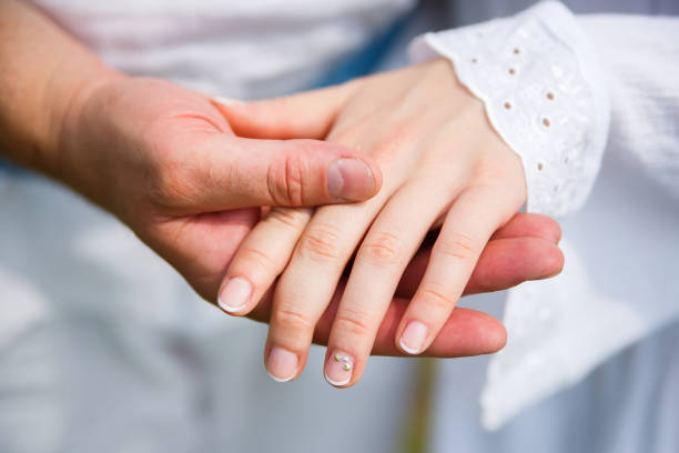 istock man holds a woman's hand in his palm 1225065827