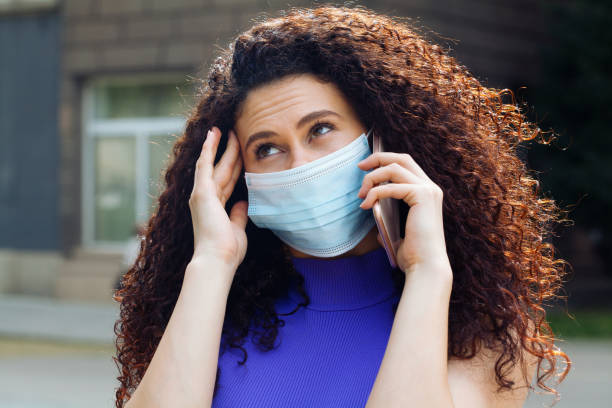 istock Young woman with a protective face mask talking on the phone 1225066162