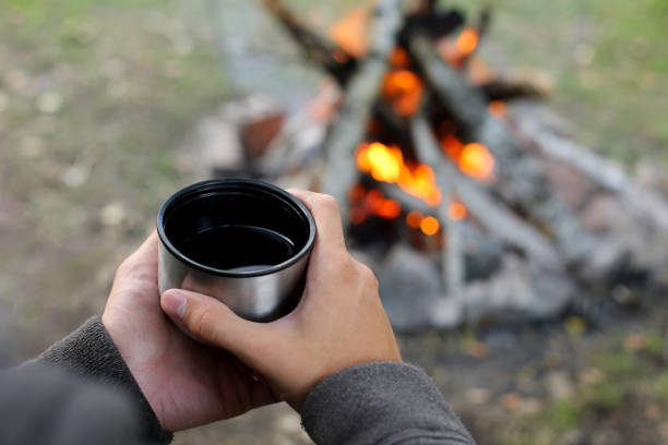 istock hands holding a mug with tea on the background of a fire 1225066233