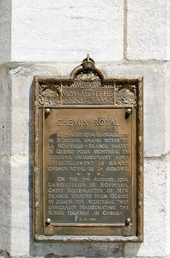 Commemorative plate explaining the Royal Path between Quebec city and Montreal was inaugurated in 1734. It is located on the St. John Gate, one of the three gates that remains from the wall fortification in the upper town of the Old Quebec city during a day of springtime