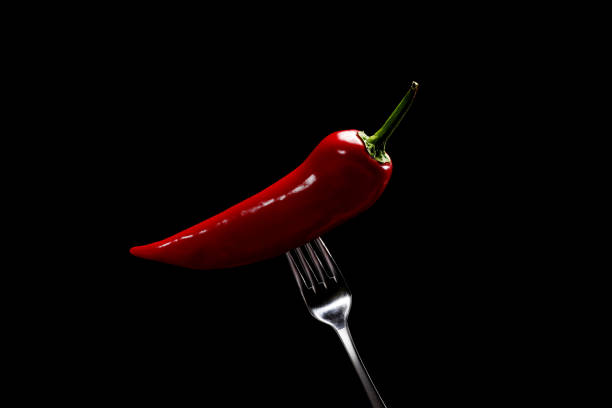 istock side view of red pepper on fork on black background. Domestic cultivation. Fresh vegetables. Vegetarian dinner. Paprika on a fork. Isolated from background 1225067197