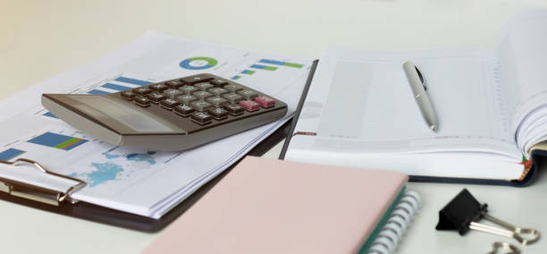 istock pen on a notebook into a cell and calculator close up 1225067218