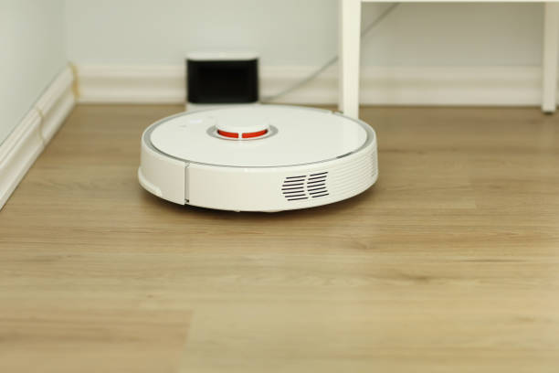 istock white robotic vacuum cleaner. The robot is controlled by voice commands for direct cleaning. Modern technology of smart cleaning. scheduled cleaning of the apartment. selective focus 1225067307