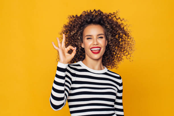 Funky young girl against yellow background Funky young girl against yellow background ok sign photos stock pictures, royalty-free photos & images