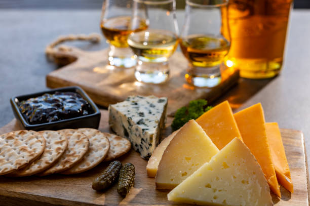 abbinamento whisky e formaggio, degustazione bicchieri di whisky e piatto con formaggi a fette - fruit and cheese foto e immagini stock