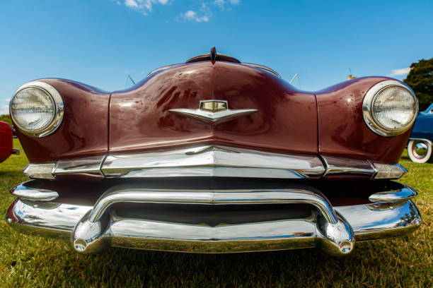 Vintage Elegance: Detailed View of a Classic Car's Chrome Headlight and Iconic Grille - Preserving Automotive History