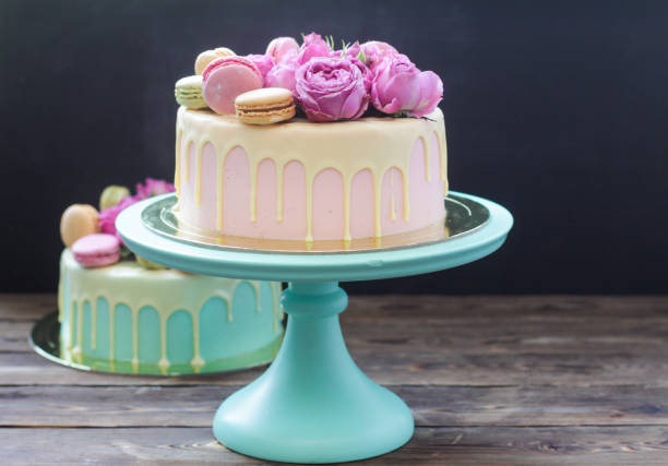 Modern pink cake with melted chocolate, fresh roses and macaroons. Black background, copy space. Modern pink cake with melted chocolate, fresh roses and macaroons. Concept for Wedding , St. Valentine's Day, Mother's Day, Birthday Cake. white wedding cake red roses stock pictures, royalty-free photos & images