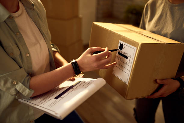 istock Unrecognizable couriers preparing packages for a delivery in the office. 1225077938