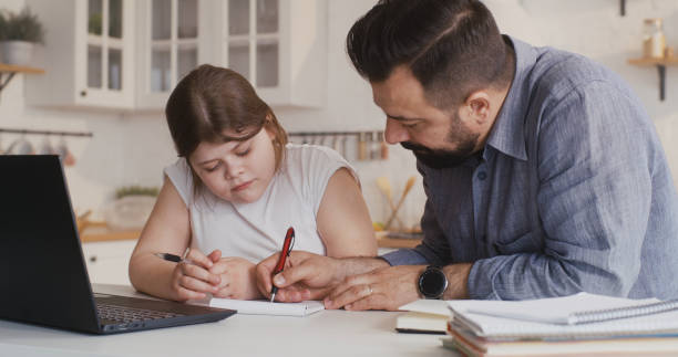 istock Daughter studying at home with his father 1225079002