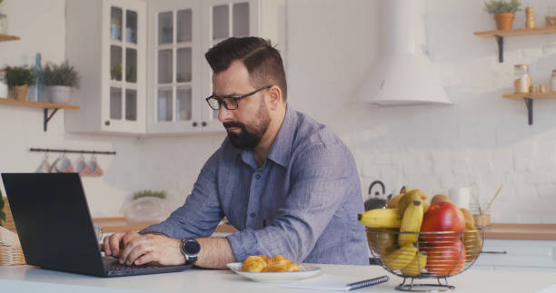 istock Man working on his laptop in the kitchen 1225079119