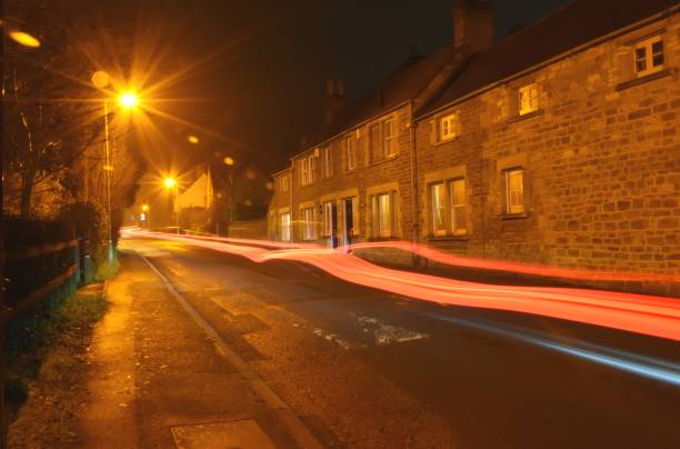 Street lights and terraced houses on a foggy road at night