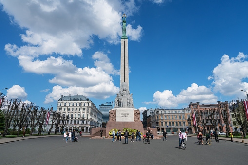 Riga, Latvia – May 4, 2020: People putting flowers by the monument as it's the day when 20 years ago Latvia proclaimed its independence from the USSR. There are so few people in the streets because of Covid-19 quarantine.