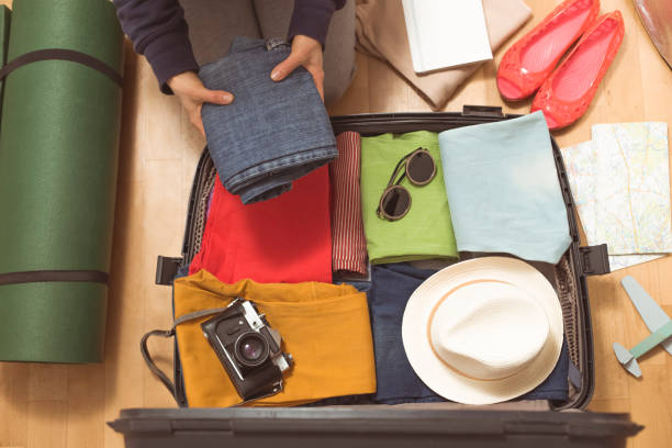 istock Female hands packing trunk bag for travel. A woman puts things into a suitcase while going on a trip. 1225086534