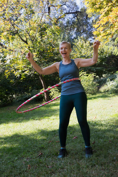 istock Mature woman using a plastic hoop at the park 1225087997