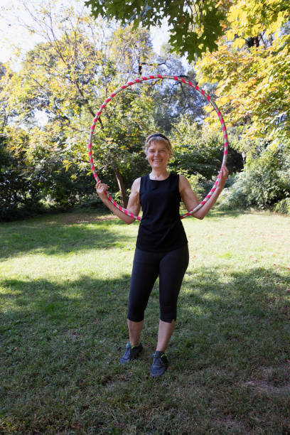 istock Mature woman using a plastic hoop at the park 1225087998