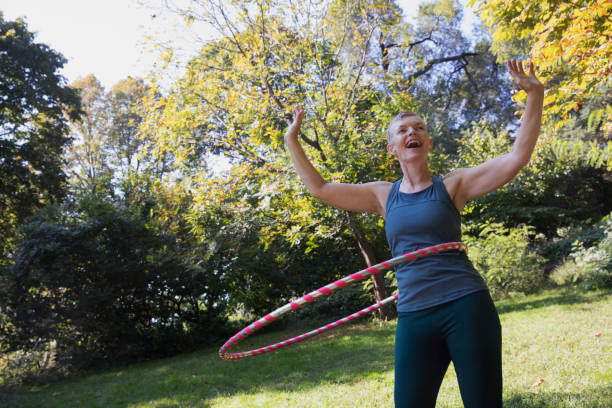 istock Mature woman using a plastic hoop at the park 1225088003