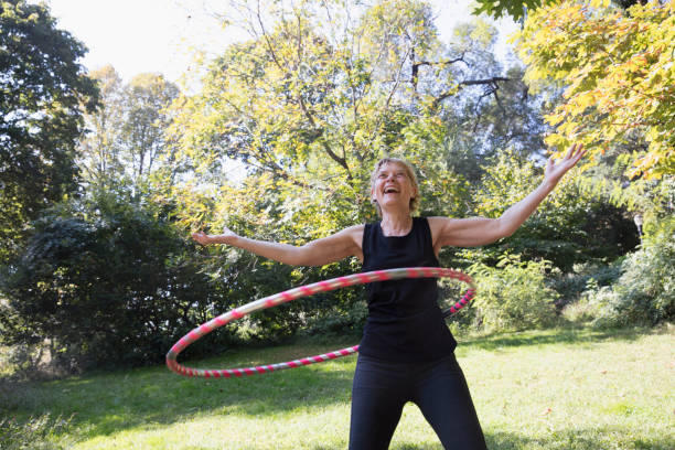 istock Mature woman using a plastic hoop at the park 1225088009