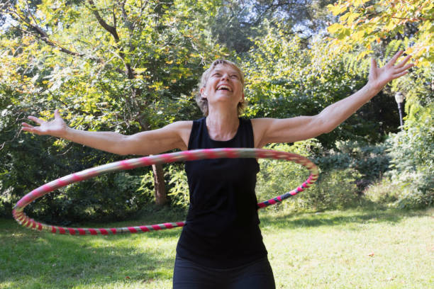 istock Mature woman using a plastic hoop at the park 1225088011