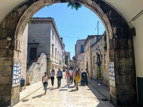 Zadar, Croatia - July 5th, 2019: Crowds of people walking through the Sea Gate into the Old Town of Zadar, Croatia on a beautiful summer day.