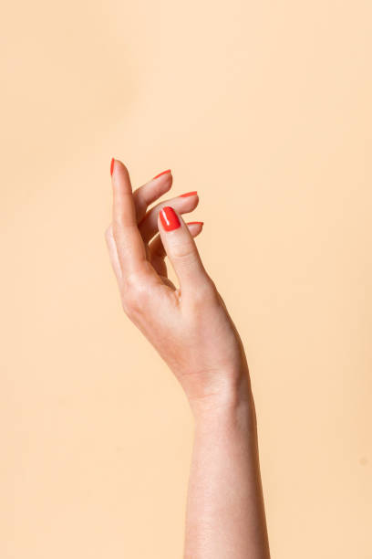 istock Empty open female hand with red manicure on a beige background 1225093962