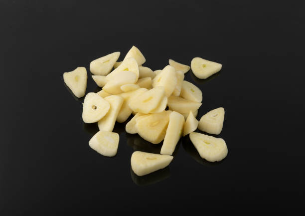 istock Fresh sliced garlic isolated on black background closeup 1225094428