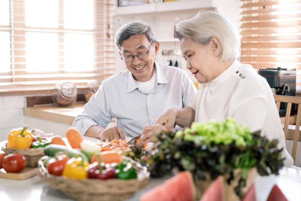 istock Senior asian couple cooking together in kitchen 1225095348