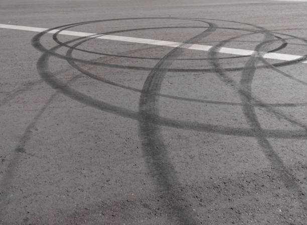 istock Black trail from rubber tires on the asphalt 1225097182
