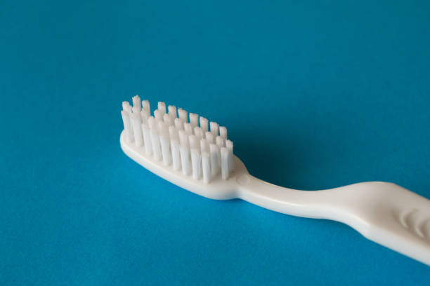 istock Close up plastic white tooth brush on blue background dental hygiene 1225101527