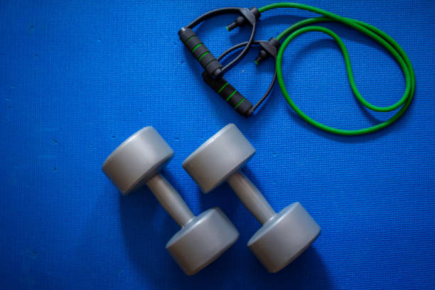 istock A pair of large grey dumbbells and a green exercise band 1225104705