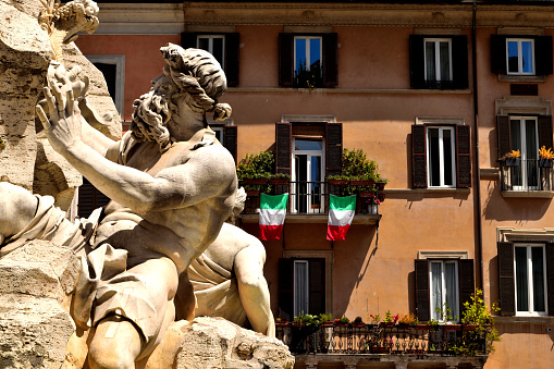 May 15th 2020, Rome, Italy: Closeup of the Four Rivers Fountain in Navona Square and italian flags during phase 2 of the lockdown