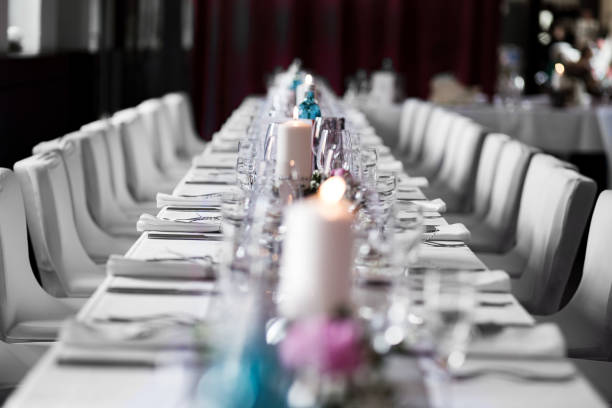 long dinner table white tablecloth candle wedding long dinner table white tablecloth candle like wedding table decoration. Event location in a restaurant. formal dinning stock pictures, royalty-free photos & images