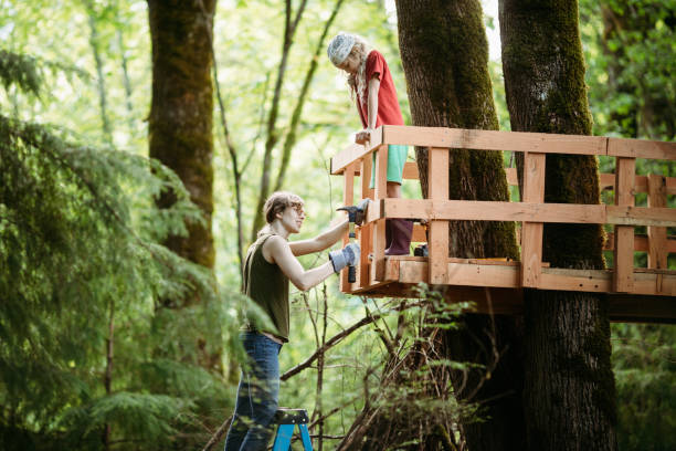 Mother And Daughter Work in Backyard Tree Fort