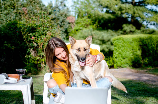 istock Beautiful young woman using tablet smiling with her dog 1225106693