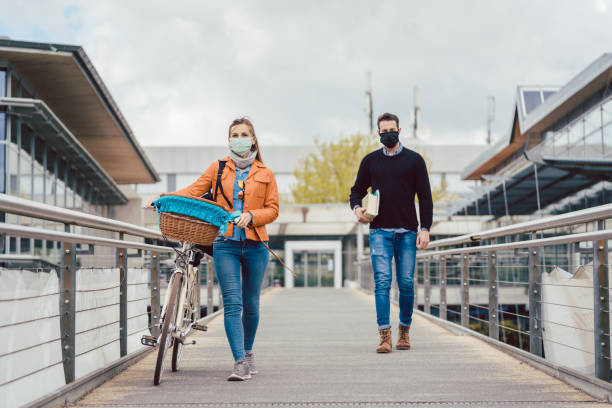 Students on university campus wearing masks during coronavirus crisis Students on university campus wearing masks during coronavirus crisis keeping social distance opening bridge stock pictures, royalty-free photos & images
